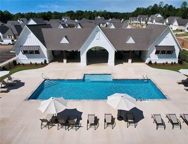 pool with a patio and a residential view
