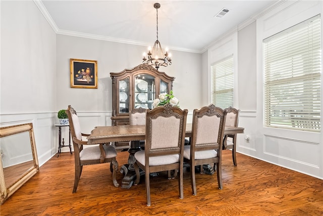 4164 Creekview Ct, Auburn, AL 36832 - dining space featuring a decorative wall, a chandelier, wood finished floors, crown molding, and a wainscoted wall