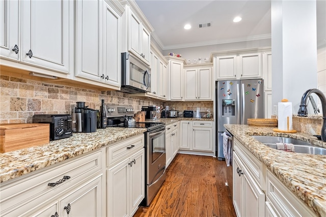 4164 Creekview Ct, Auburn, AL 36832 - kitchen featuring stainless steel appliances, ornamental molding, wood finished floors, light stone countertops, and white cabinetry