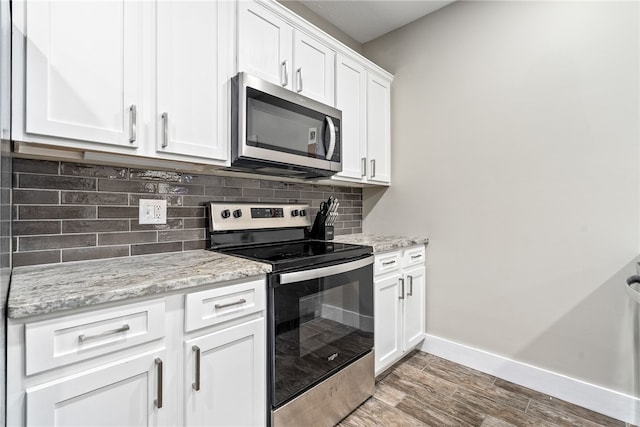 303 N Ross St Unit 104, Auburn, AL 36830 - kitchen with stainless steel appliances, baseboards, tasteful backsplash, and light wood-style flooring