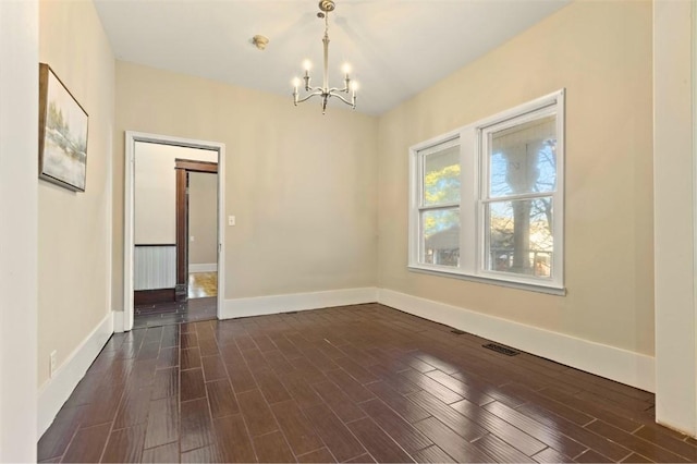 unfurnished room featuring an inviting chandelier