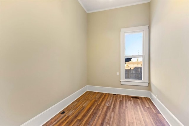 empty room with ornamental molding and dark hardwood / wood-style flooring