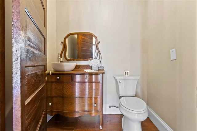 bathroom with wood-type flooring, toilet, and vanity