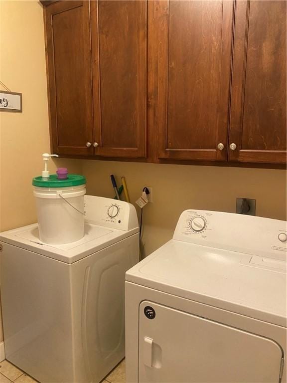 washroom with light tile patterned floors, cabinets, and independent washer and dryer