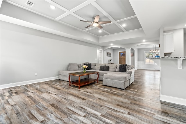 living room featuring visible vents, arched walkways, coffered ceiling, and wood finished floors