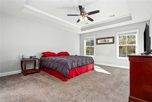 carpeted bedroom featuring visible vents, crown molding, a tray ceiling, and baseboards