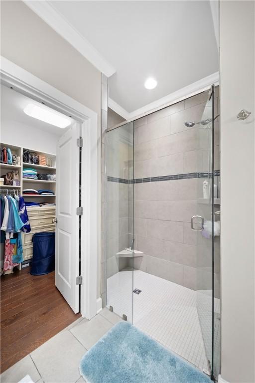 3412 Double Eagle Ln, Opelika, AL 36801 - bathroom with tile patterned floors, a stall shower, a walk in closet, crown molding, and recessed lighting
