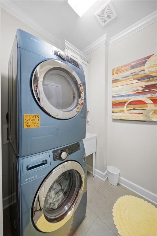 3412 Double Eagle Ln, Opelika, AL 36801 - washroom featuring stacked washer / drying machine, crown molding, light tile patterned floors, and baseboards