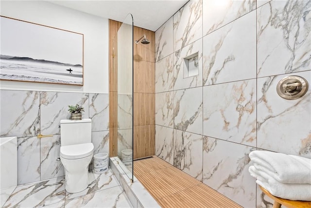 bathroom featuring toilet, tiled shower, and tile walls