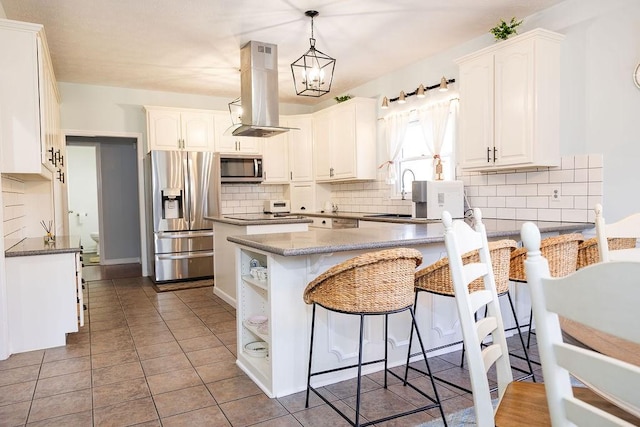 255 Hedgerow Cir, Auburn, AL 36830 - kitchen featuring stainless steel appliances, island range hood, backsplash, white cabinets, and a peninsula