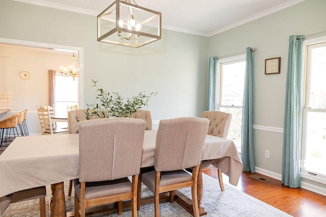255 Hedgerow Cir, Auburn, AL 36830 - dining area with a chandelier, wood finished floors, and ornamental molding