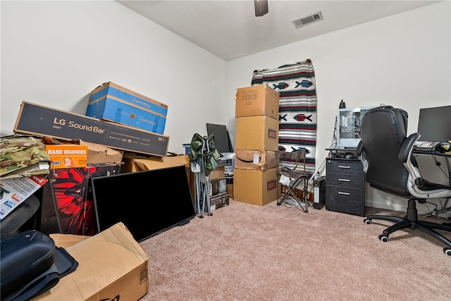 carpeted home office featuring ceiling fan and a textured ceiling