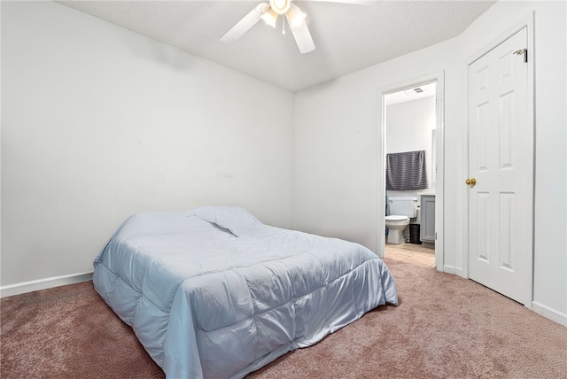 carpeted bedroom with ceiling fan and ensuite bath