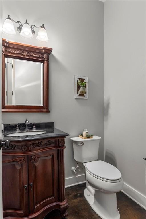 bathroom with hardwood / wood-style flooring, toilet, and vanity