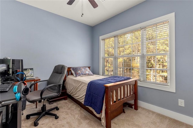 bedroom with ceiling fan, light colored carpet, and multiple windows