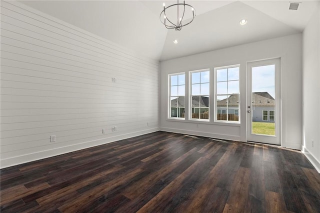 empty room featuring vaulted ceiling, baseboards, dark wood finished floors, recessed lighting, and a chandelier