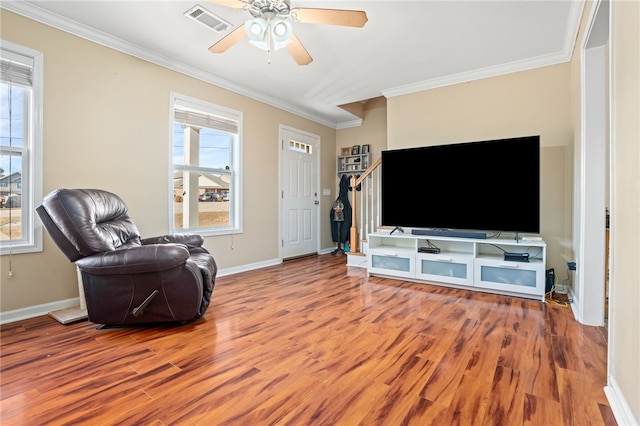 living room featuring a wealth of natural light, ceiling fan, ornamental molding, and hardwood / wood-style flooring