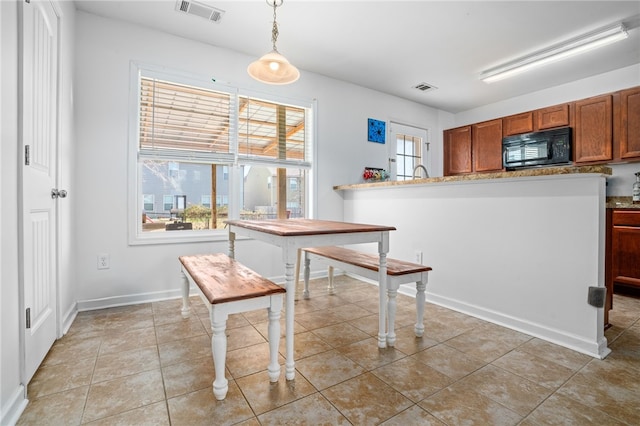 kitchen with light tile patterned floors and hanging light fixtures