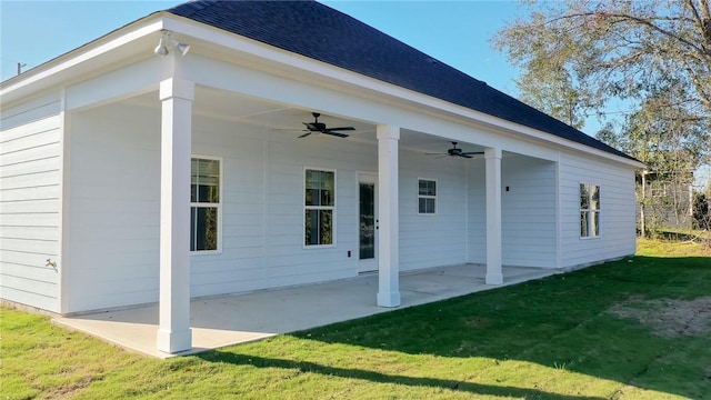 rear view of property with ceiling fan, a patio area, and a lawn