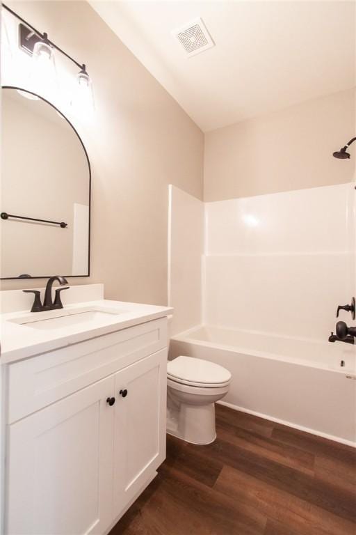 full bathroom with bathing tub / shower combination, vanity, wood-type flooring, and toilet