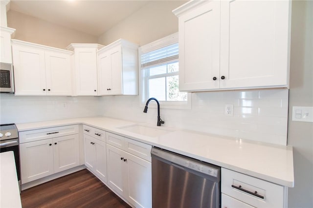 kitchen featuring white cabinetry, sink, stainless steel appliances, tasteful backsplash, and dark hardwood / wood-style floors