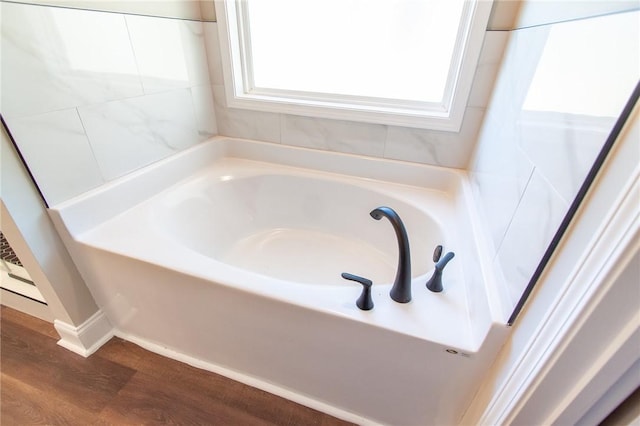 bathroom with wood-type flooring and a bathing tub