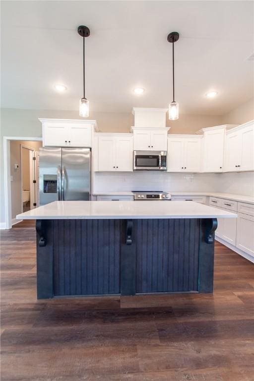 kitchen featuring white cabinets, appliances with stainless steel finishes, a center island, and pendant lighting