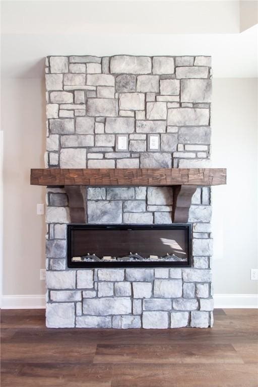 interior details featuring hardwood / wood-style floors and a stone fireplace