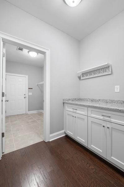 clothes washing area with dark hardwood / wood-style floors