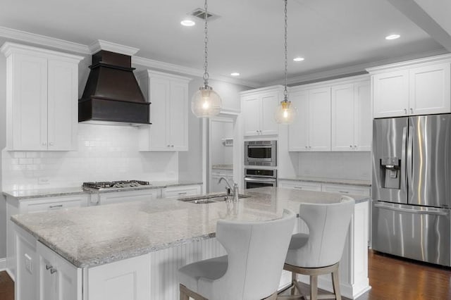 kitchen featuring premium range hood, an island with sink, white cabinets, and appliances with stainless steel finishes