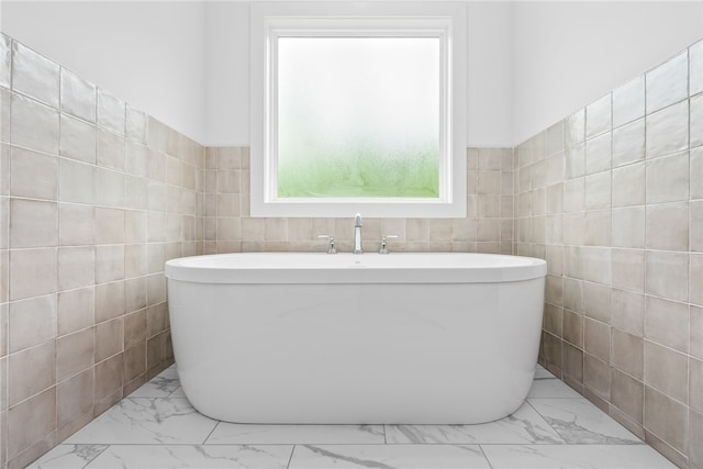 bathroom featuring a tub to relax in and tile walls