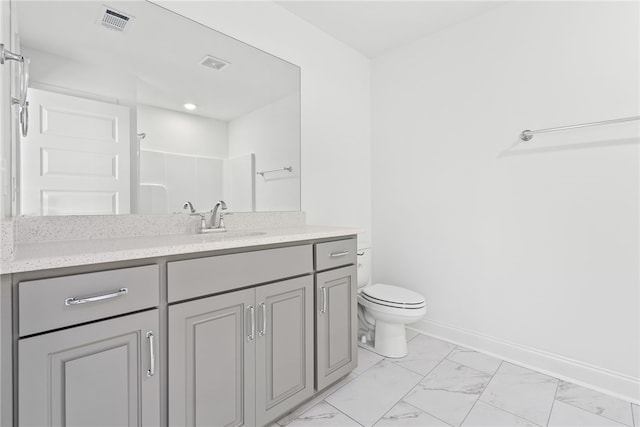 bathroom featuring vanity, toilet, and a shower