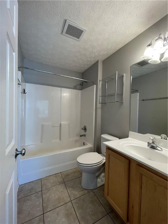1385 S Donahue Dr Unit 4201, Auburn, AL 36832 - bathroom featuring toilet, tile patterned flooring, a textured ceiling, vanity, and shower / washtub combination