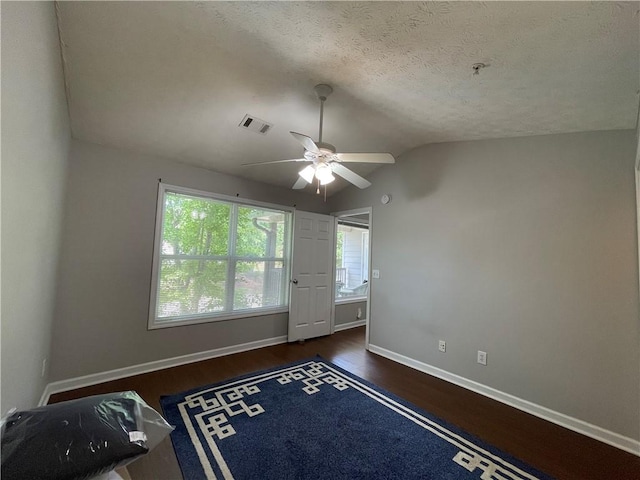1385 S Donahue Dr Unit 4201, Auburn, AL 36832 - unfurnished bedroom featuring wood finished floors, lofted ceiling, baseboards, a textured ceiling, and ceiling fan