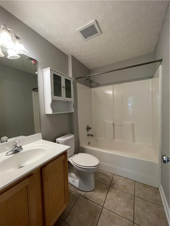 1385 S Donahue Dr Unit 4201, Auburn, AL 36832 - full bath featuring a textured ceiling, tile patterned flooring, vanity, toilet, and bathtub / shower combination