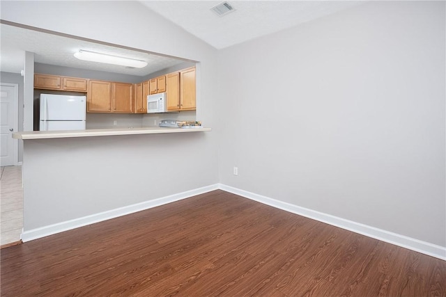 1385 S Donahue Dr Unit 4201, Auburn, AL 36832 - kitchen with white appliances, dark wood-type flooring, light countertops, a peninsula, and vaulted ceiling