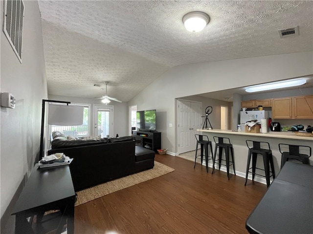 1385 S Donahue Dr Unit 4201, Auburn, AL 36832 - living room with dark wood-style flooring, a textured ceiling, a ceiling fan, lofted ceiling, and baseboards