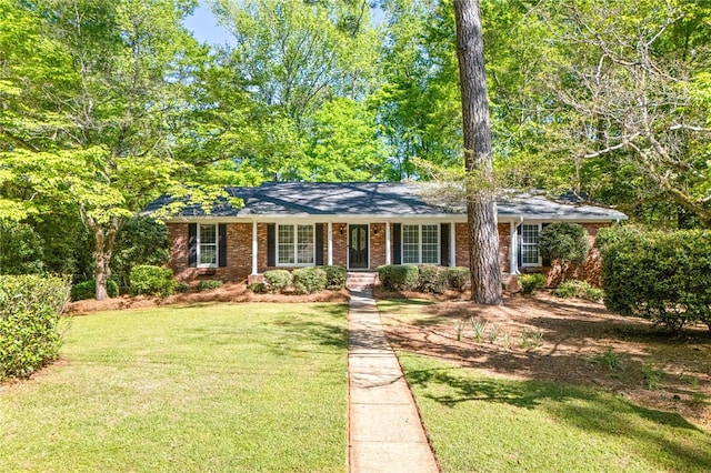 ranch-style house with a front lawn, brick siding, and covered porch