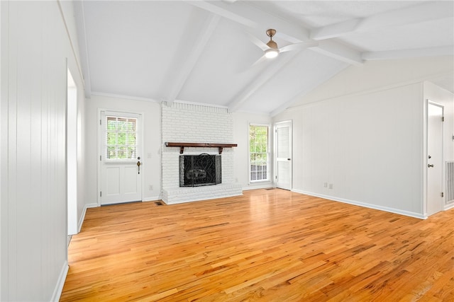 unfurnished living room featuring plenty of natural light, ceiling fan, a brick fireplace, and light wood-type flooring