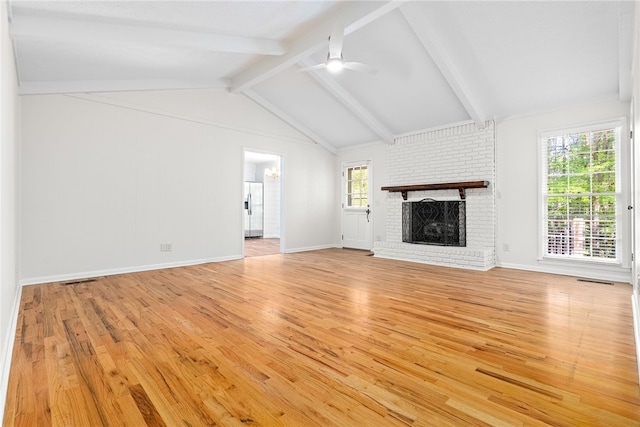 unfurnished living room featuring vaulted ceiling with beams, a brick fireplace, light wood-style floors, and ceiling fan