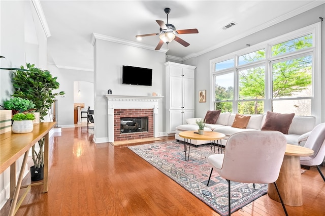 2674 Canal Ct, Auburn, AL 36830 - living room featuring visible vents, a fireplace, light wood finished floors, crown molding, and a ceiling fan