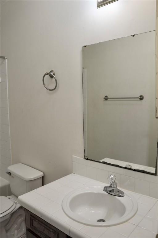 bathroom with a washtub, walk in shower, vanity, and toilet