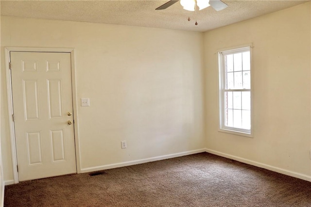 unfurnished room with a textured ceiling, dark colored carpet, a ceiling fan, and baseboards