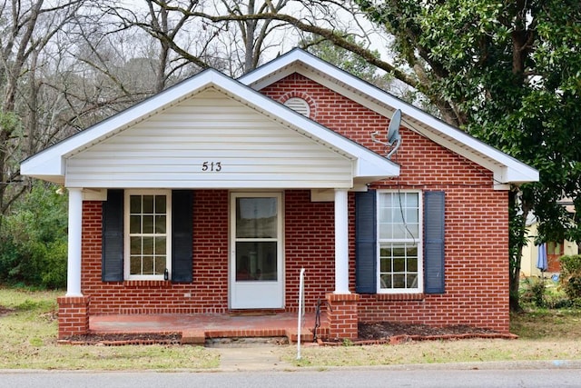 bungalow-style house with a porch and brick siding