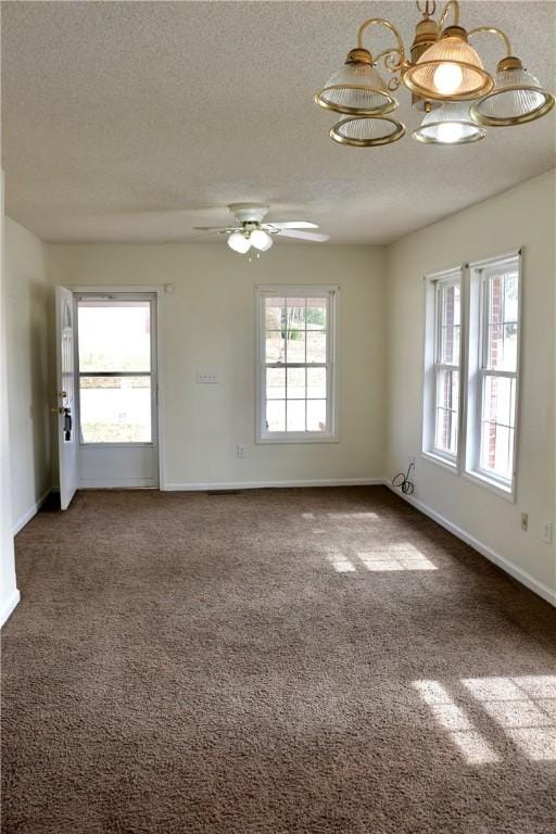 carpeted spare room featuring a textured ceiling, ceiling fan, a wealth of natural light, and baseboards