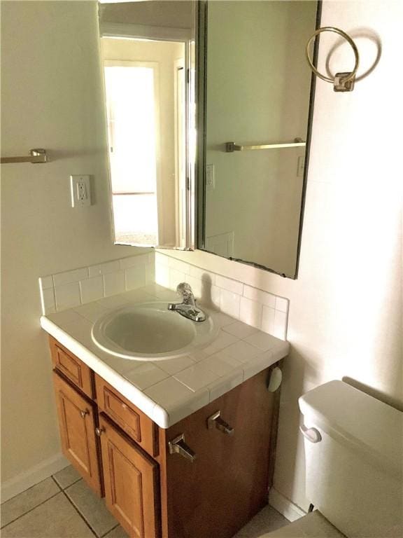 bathroom featuring tile patterned flooring, vanity, and toilet