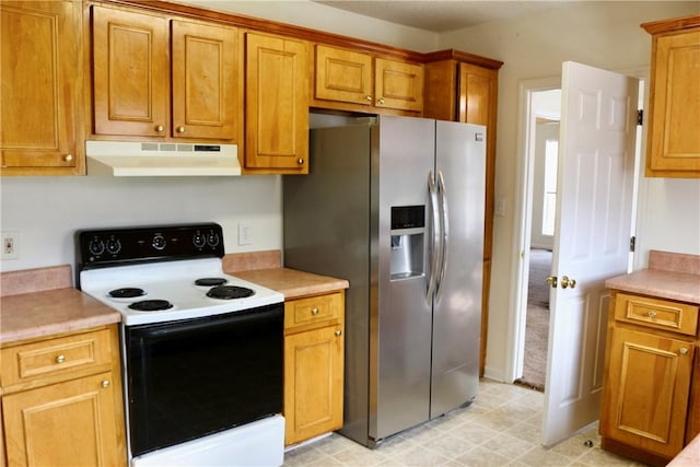 kitchen with under cabinet range hood, stainless steel fridge, light countertops, and electric range oven