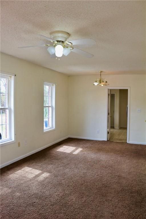 carpeted spare room with a textured ceiling, baseboards, and ceiling fan with notable chandelier