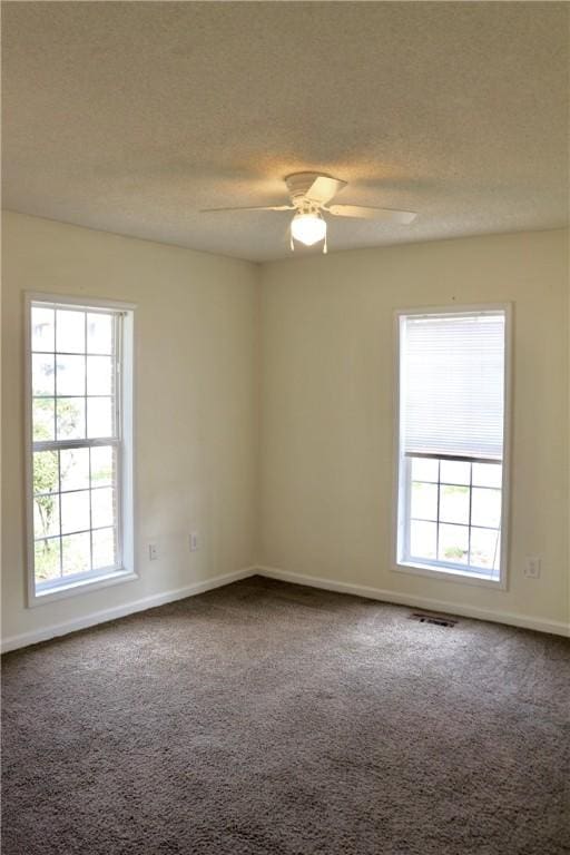 unfurnished room featuring dark colored carpet, ceiling fan, a textured ceiling, and baseboards