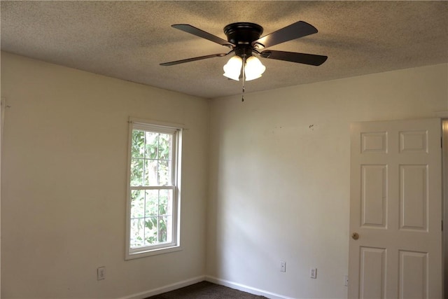 unfurnished room featuring baseboards, a ceiling fan, and a textured ceiling